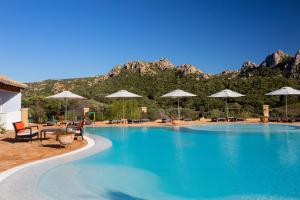 uma grande piscina com cadeiras e guarda-sóis em Hotel Parco Degli Ulivi - Sardegna em Arzachena