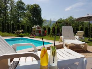 un patio con mesa, sillas y piscina en GOŚCINIEC GROBLICE en Ustroń