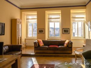 a living room with a couch and windows at Marktblick - Ferienwohnungen LAUM Altenburg in Altenburg