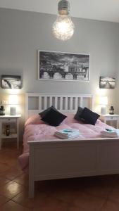 a bedroom with a large white bed with pink sheets at Villa Vittorio in Infernetto