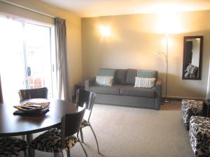 a living room with a table and a couch at Buller Court on Palmerston in Westport