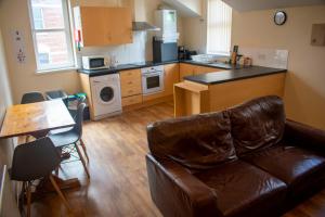 a living room with a couch and a kitchen at Titanic Apartments Belfast in Belfast