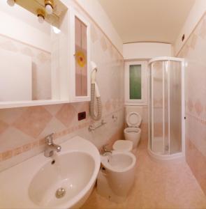 a bathroom with a sink and a shower and a toilet at Hotel Trevi in Lido di Jesolo