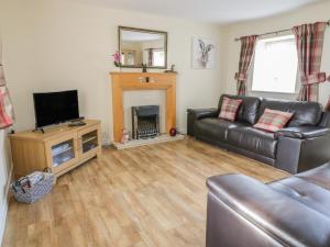 a living room with a couch and a fireplace at Stable Cottage Llandudno in Llandudno