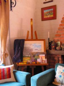 een woonkamer met 2 stoelen en een tafel met een schilderij bij La Paleta del Pintor Hosteria in Maimará