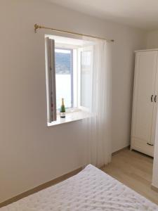 a bedroom with a window and a white mattress at Rooms in Primošten +2 photos
