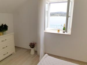 a white room with a window and a dresser at Rooms in Primošten