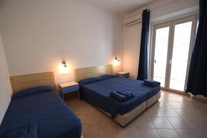 um quarto com 2 camas e uma janela em Hotel la Conchiglia em Campo nell'Elba