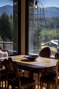 mesa de comedor con sillas y ventana grande en BOG Casa Soñada en Villa La Angostura