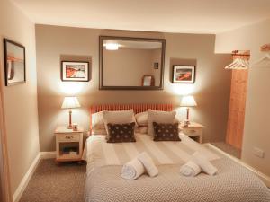 ein Schlafzimmer mit einem Bett mit Kissen und einem Spiegel in der Unterkunft Little Brook in Broadwey