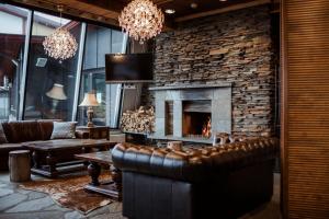 a living room with a couch and a fireplace at Lapland Hotels Saaga in Ylläsjärvi