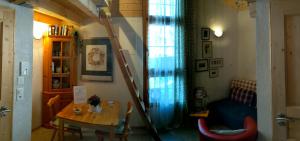 ein Wohnzimmer mit einem Tisch und einer Treppe in der Unterkunft Casa Acazia - Studio in Brigels