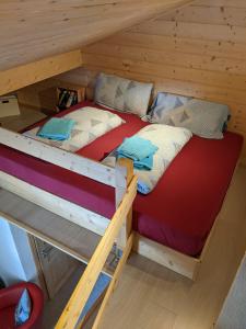 Ce lit superposé se trouve dans un dortoir en bois doté d'un couvre-lit. dans l'établissement Casa Acazia - Studio, à Brigels