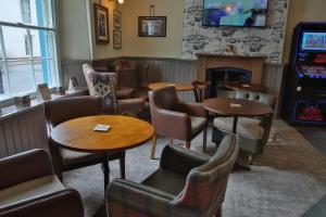 a waiting room with tables and chairs and a fireplace at The Seale Arms in Dartmouth