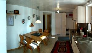 a kitchen with a table and chairs in a room at Casa Acazia in Breil/Brigels