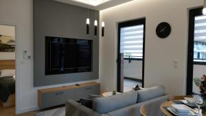 - un salon avec un canapé et une télévision dans l'établissement Apartament SunPark, à Przemyśl