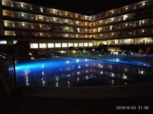 a swimming pool in front of a building at night at Hotel Esplendid in Blanes