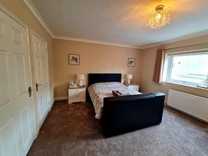1 dormitorio con cama, ventana y mesa en Southcote en Weston-super-Mare