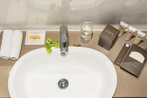 a sink with a toothbrush, toothpaste, and other items on it at Pullman Melbourne Albert Park in Melbourne