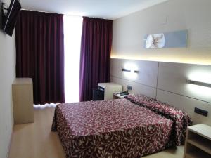 een hotelkamer met een bed en een raam bij Hotel Esplendid in Blanes