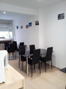 a dining room with black chairs and a table at Casa María in Málaga