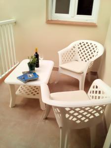 a white table and chairs with a bottle of wine at Casa María in Málaga