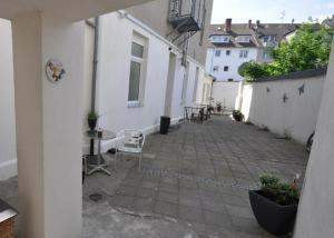 an empty courtyard of a white building with a chair at Apartment Dusseldorf-City in Düsseldorf