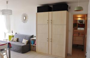 a large cabinet in a living room with a couch at Studio Front de Mer in Saint-Jean-de-Monts