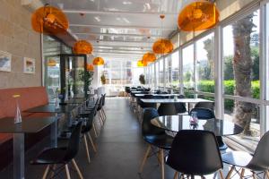 a restaurant with tables and chairs and large windows at Hotel Miera in Liérganes