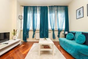 - un salon avec un canapé bleu et une table dans l'établissement [PISA STAZIONE - CENTRO] Appartamento Elegante con Netflix, à Pise