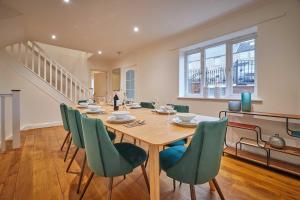 a dining room with a wooden table and green chairs at Host & Stay - Strathview in Hexham