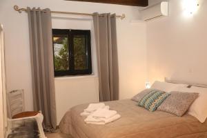 a bedroom with a bed with towels on it at Xigia Escape villas in Khartáta