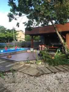 a backyard with a wooden deck with a table and chairs at Maná Mariscal Hospedagem in Bombinhas
