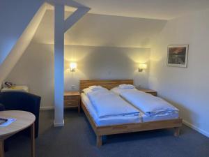 a bedroom with a bed with blue pillows on it at Hotel Wintersmühle in Bielefeld +66 photos