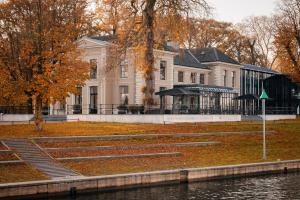 Un grand bâtiment blanc avec des feuilles d'automne dans l'établissement Pillows Luxury Boutique Hotel aan de IJssel, à Deventer