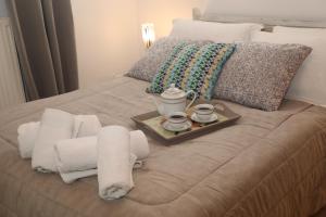 a bed with a tray of towels and two cups and a tray of towels at Xigia Escape villas in Khartáta
