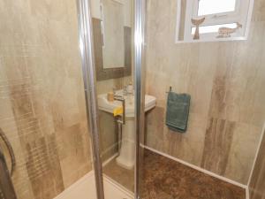 a bathroom with a shower and a sink at Hardy Cottage in Benllech +21 photos