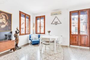a living room with a table and a blue chair at Ca Lu Vintage Flat con Vista su San Marco! in Venice