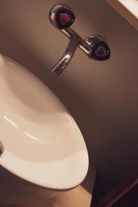 a white sink in a bathroom with a faucet at Pension Sonne in Adelboden