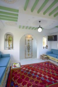 sala de estar con sofá azul y alfombra roja en Dar El Yasmine Tunis, en Túnez