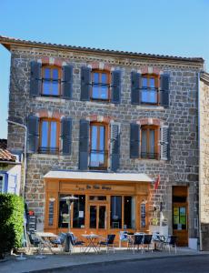 a building with tables and chairs in front of it at Les Trois Temps in Saint-Didier-sur-Rochefort