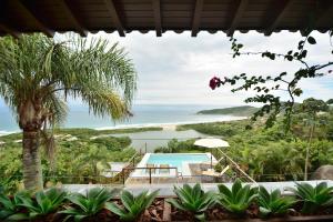 a view of the ocean from a house at Villa Gardena Suites in Praia do Rosa +41 photos