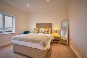 a bedroom with a large bed and a mirror at Host & Stay - Strathview in Hexham