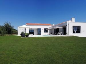 une maison blanche avec une grande pelouse devant elle dans l'établissement Villa Una Sofia, à Pazin