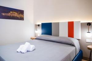 a bedroom with a bed with two towels on it at Incao Holiday Giudecca House in Cefalù