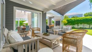 a porch with chairs and a table and a television at Narnia on Thesen Island in Knysna