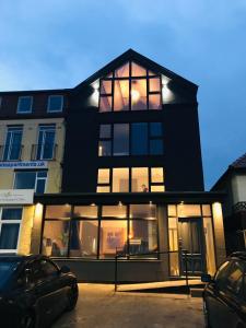 une maison noire avec de grandes fenêtres dans un parking dans l'établissement Onyx House, à Blackpool