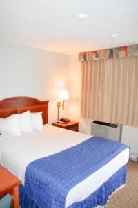 una camera d'albergo con un letto con una coperta blu di Knights Inn North Attleboro a North Attleboro