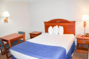 North AttleboroにあるKnights Inn North Attleboroのベッドとデスクが備わるホテルルームです。