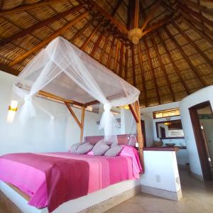 a bed in a room with a wooden roof at Zazil Retreat in San Agustinillo